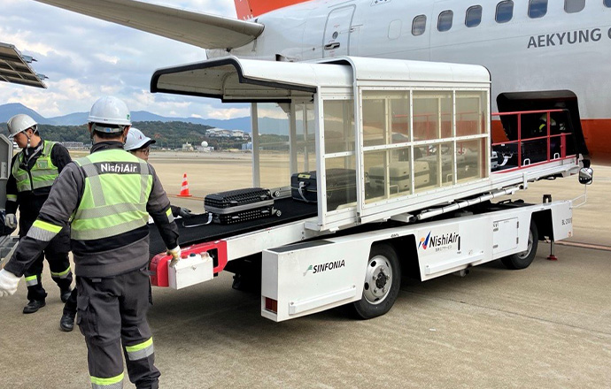 ベルトコンベアーで航空機へ荷物の積み込み
